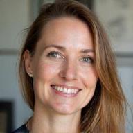 Portræt af Emma Jensen, en kreativ interiørdesigner med et tankefuldt udtryk, der skitserer på et designbræt i et moderne, minimalistisk kontor.